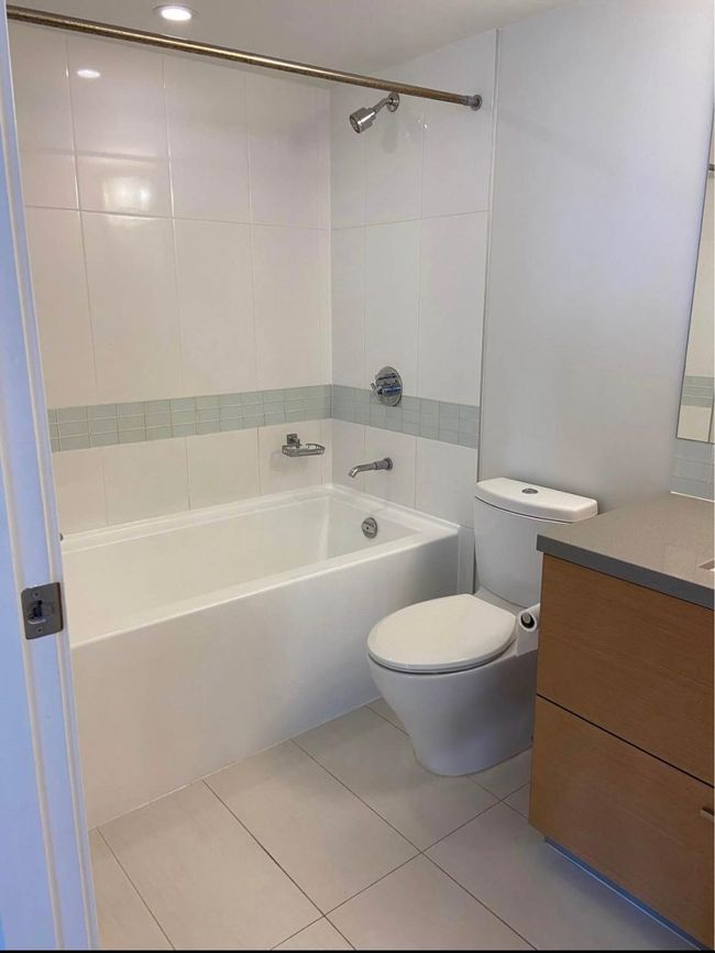 Bathroom with bathing tub / shower combination, toilet, tile patterned flooring, and vanity | Image 15