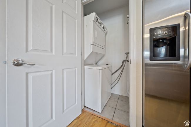 Laundry area featuring stacked washer / dryer and light tile patterned floors | Image 25