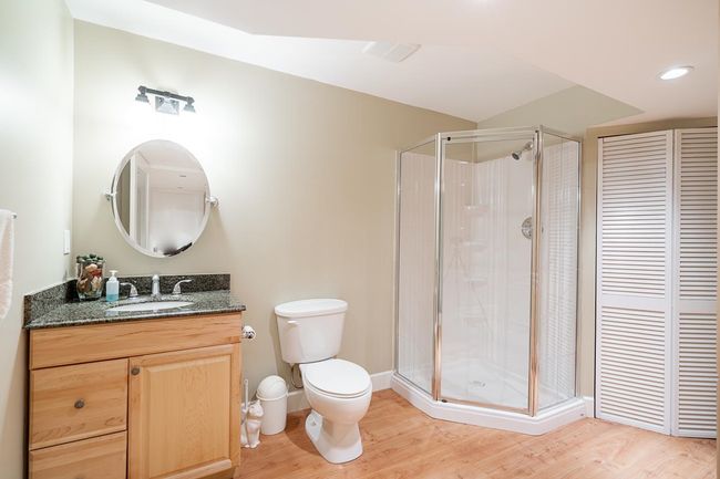 Full bath featuring a stall shower, vanity, wood finished floors, and a closet | Image 29