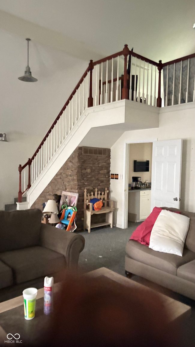 Overswized Rec Room with bar area with staircase to additional loft area carpeted living area with stairs and a towering ceiling | Image 4