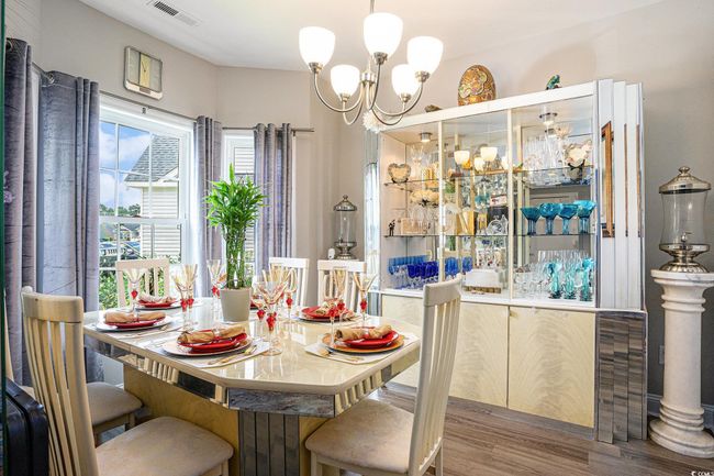 Dining area featuring wood finished floors and a chandelier | Image 6