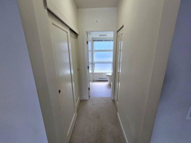 Corridor with carpet floors, a baseboard heating unit, and baseboards | Image 14