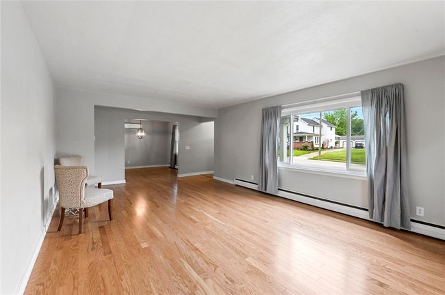 The expansive living room offers engineered hardwood floors and a large window to allow for plenty of natural light. | Image 5