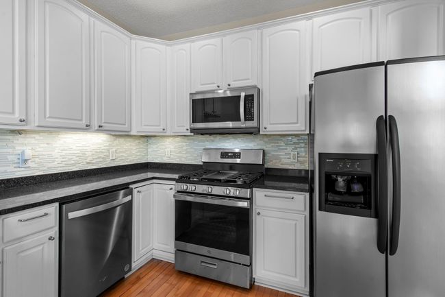 Stainless steel appliances with matching silver cabinet hardware on the more than ample cupboard space. | Image 19