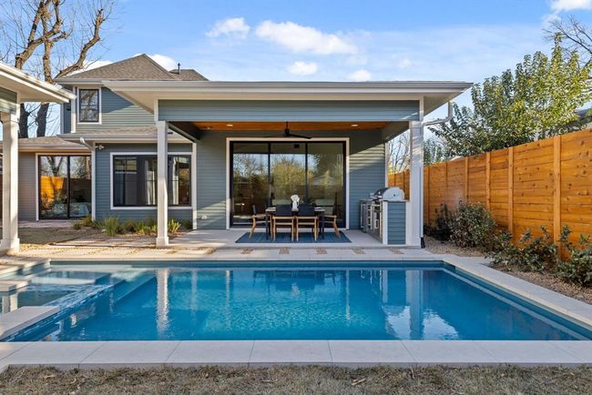 Rear view of house with a fenced backyard, a patio, a pool with connected hot tub, and roof with shingles | Image 36
