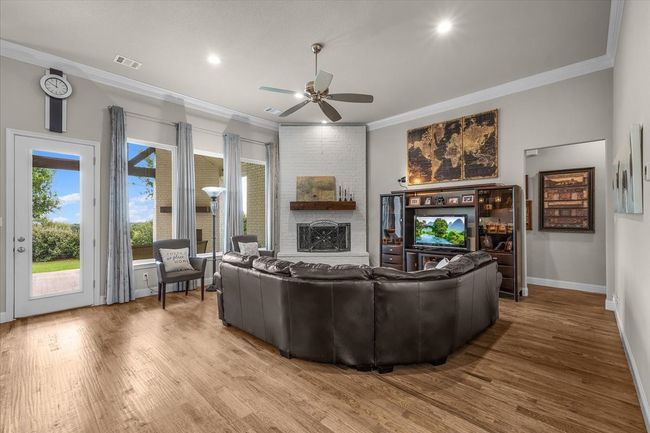 Living room featuring crown molding & views of the landscaped backyard | Image 9