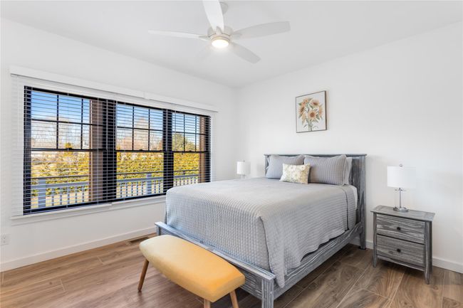 Bedroom with visible vents, ceiling fan, baseboards, and wood finished floors | Image 12