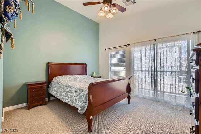 View of the Primary bedroom, featuring lofted ceiling, ceiling fan/light, window lighting and carpeting . | Image 12