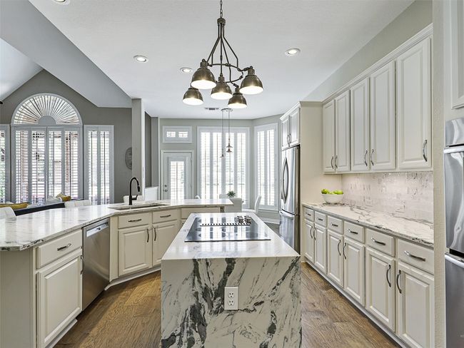 Kitchen featuring appliances with stainless steel finishes, a center island, a chandelier, recessed lighting, and backsplash | Image 15