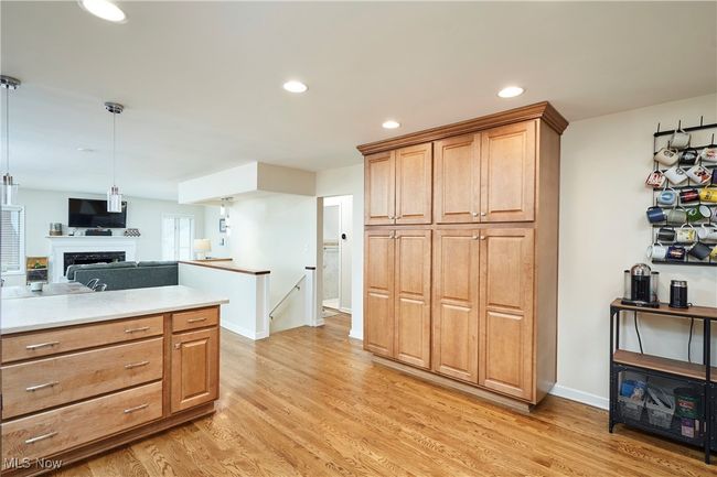 Kitchen with light wood-type flooring, light countertops, a fireplace, recessed lighting, and open floor plan | Image 15