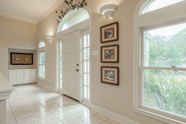 Entrance foyer featuring light tile patterned floors, crown molding, and baseboards | Image 6