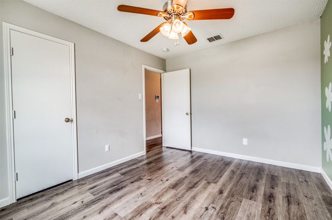 Unfurnished bedroom with wood finished floors, baseboards, and ceiling fan | Image 17