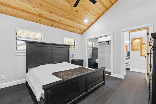 Bedroom featuring wood ceiling, baseboards, vaulted ceiling, and dark wood-style flooring | Image 7