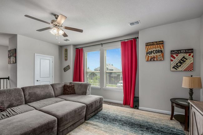 Living area featuring baseboards, a ceiling fan, and carpet | Image 17