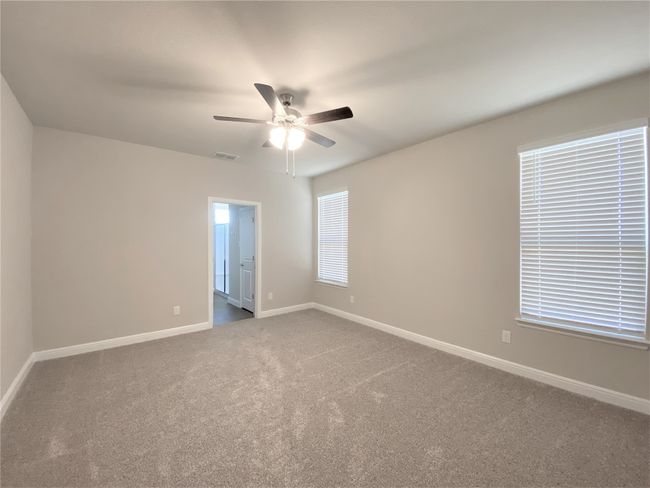 Empty room with a ceiling fan and carpet flooring | Image 5