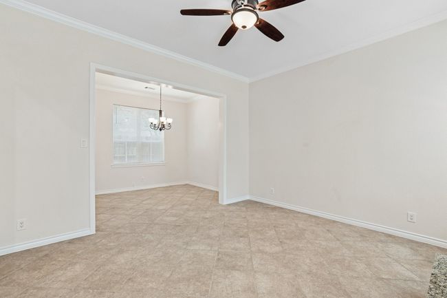 Spare room featuring ornamental molding, a ceiling fan, and a chandelier | Image 8