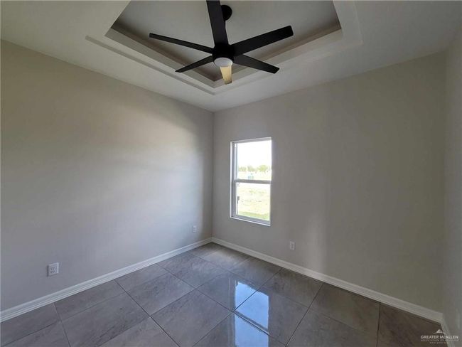 Unfurnished room featuring ceiling fan, light tile patterned floors, and a raised ceiling | Image 14