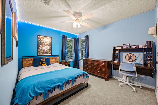 Bedroom featuring light carpet, a textured ceiling, and a ceiling fan | Image 27