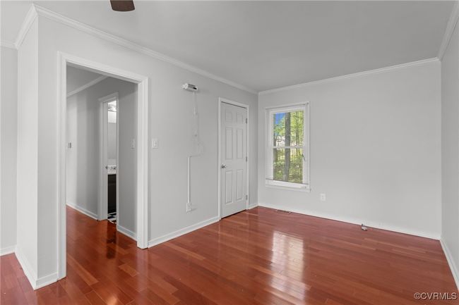 Spare room featuring baseboards, crown molding, and wood finished floors | Image 4