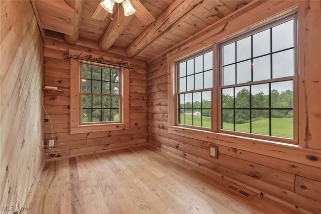 First floor second bedroom, possible office with wood floors and windows overlooking back of the home | Image 16