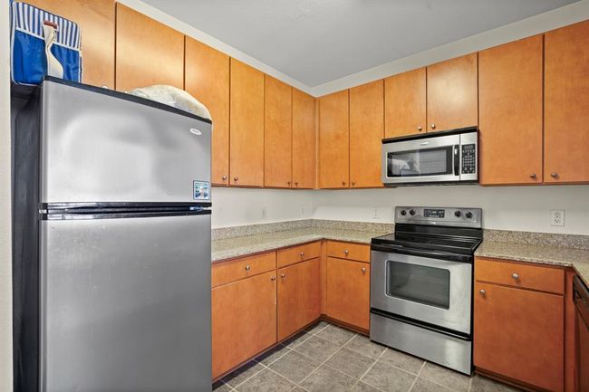 Kitchen featuring stainless steel appliances, light countertops, and light tile patterned floors | Image 4
