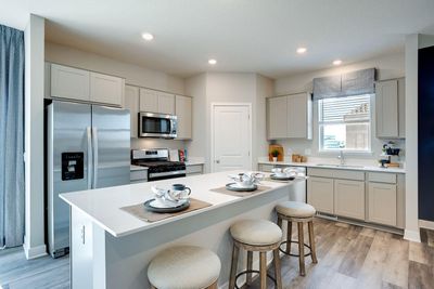 A kitchen built to perform - complete with an oversized island, pantry closet, stainless appliance package including a vented micro-hood, gas range, and enough space throughout for the family chef to roam about! | Image 1