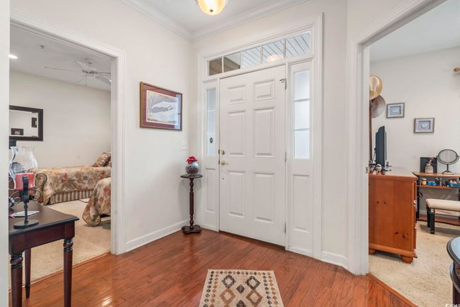Entryway featuring dark wood finished floors, ornamental molding, and a ceiling fan | Image 15
