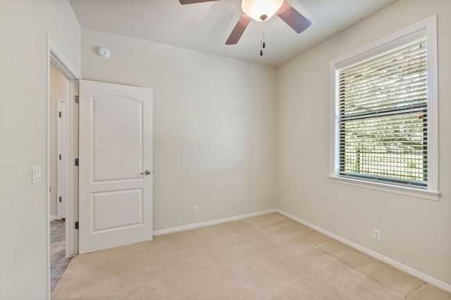 Spare room featuring light carpet, a smoke detector, and ceiling fan | Image 19