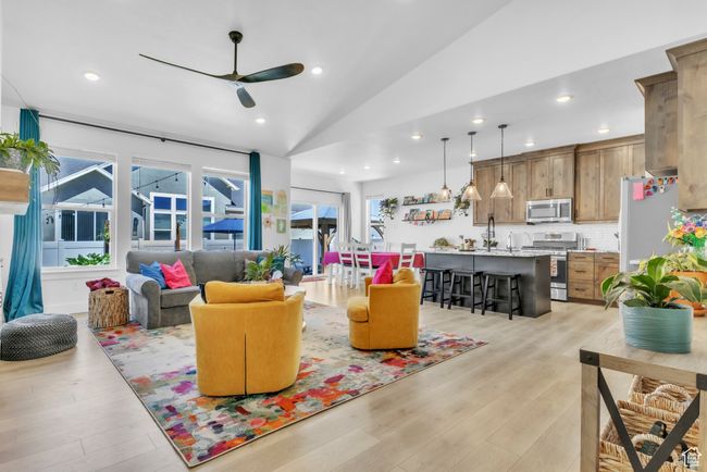 Living room with a ceiling fan, lofted ceiling, light wood finished floors, and recessed lighting | Image 6