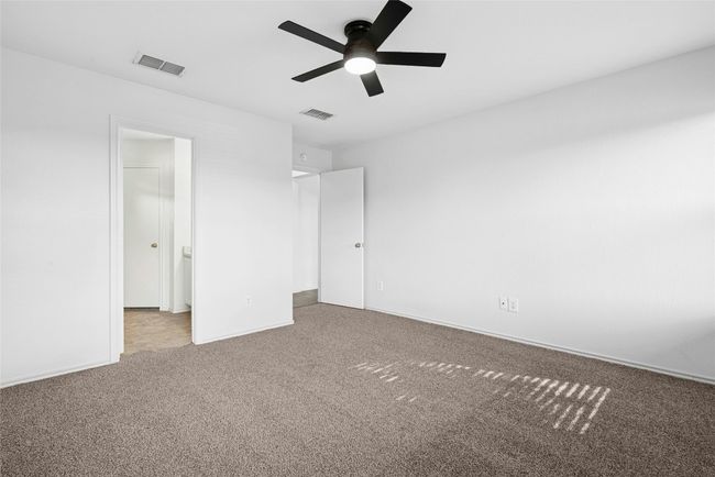 Unfurnished bedroom featuring carpet floors, a walk in closet, and a ceiling fan | Image 14