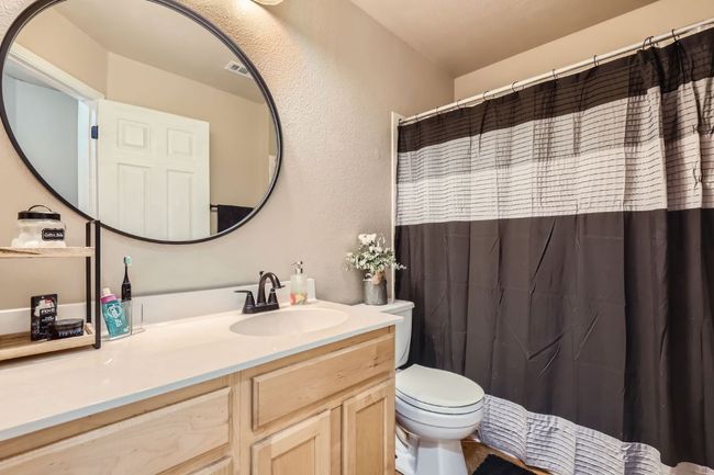 Bathroom with vanity, a textured wall, and a shower with shower curtain | Image 19