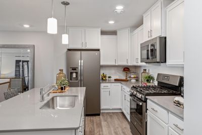 (Photo of decorated model, actual home's finishes may vary slightly) Enjoy plenty of seating at the kitchen island and dining area adjacent to the kitchen. Perfect for entertaining or having a family meal together. | Image 3