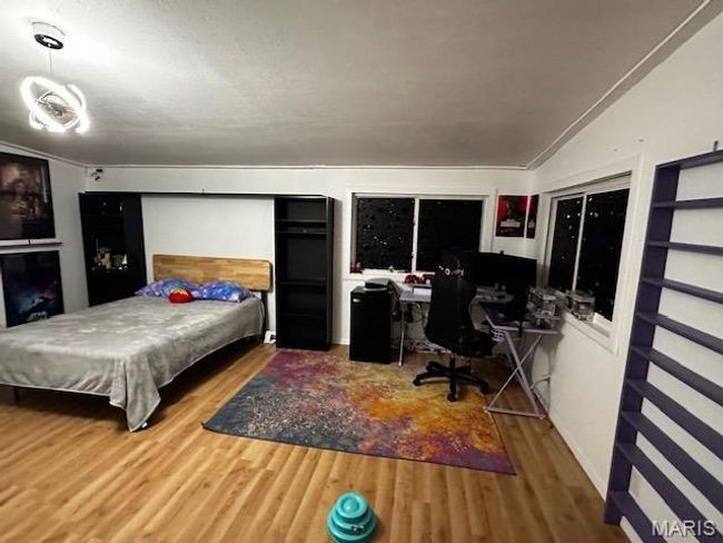 Bedroom featuring vaulted ceiling, hardwood / wood-style flooring, and ornamental molding | Image 6