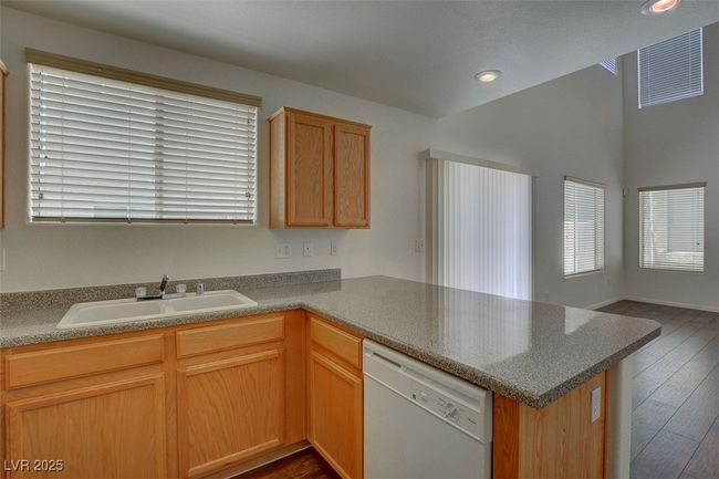 Kitchen with a sink, plenty of natural light, dark wood-style flooring, dishwasher, and a peninsula | Image 11