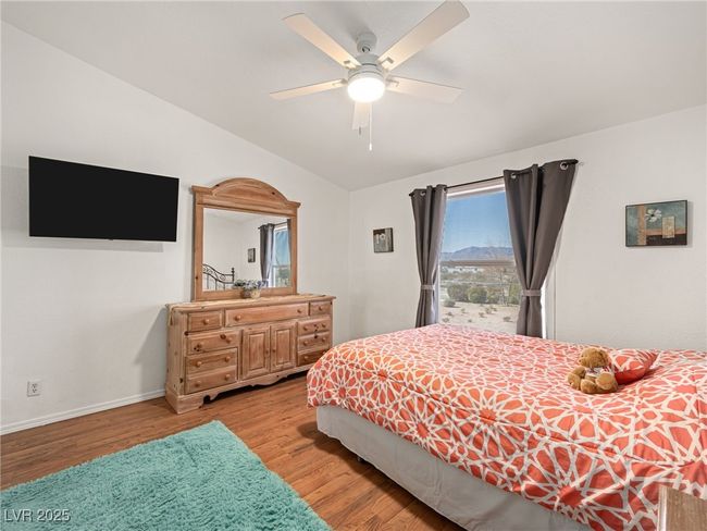 Bedroom featuring light wood-type flooring, baseboards, and a ceiling fan | Image 37