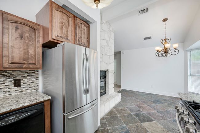 Kitchen featuring appliances with stainless steel finishes, visible vents, a chandelier, decorative backsplash, and vaulted ceiling with beams | Image 15
