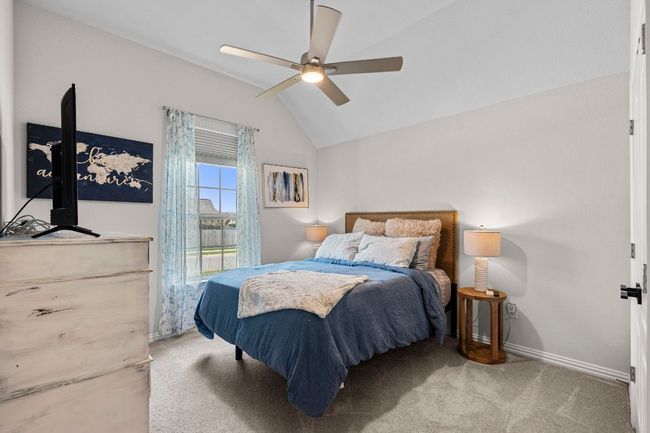 Carpeted bedroom with lofted ceiling, ceiling fan, and baseboards | Image 19