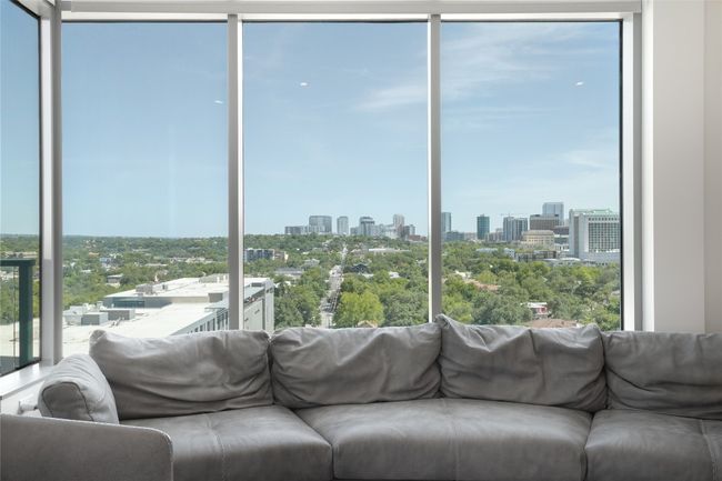 Sunroom featuring a skyline view and view of wooded area | Image 9