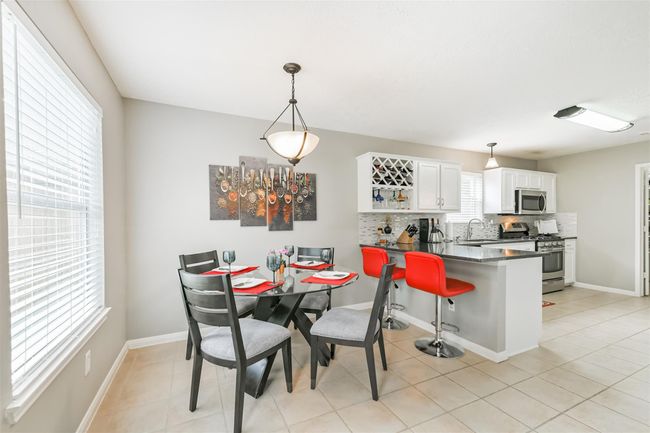 The breakfast area overlooks the back yard through this oversized window. The breakfast bar provides for more seating and entertaining areas. | Image 9