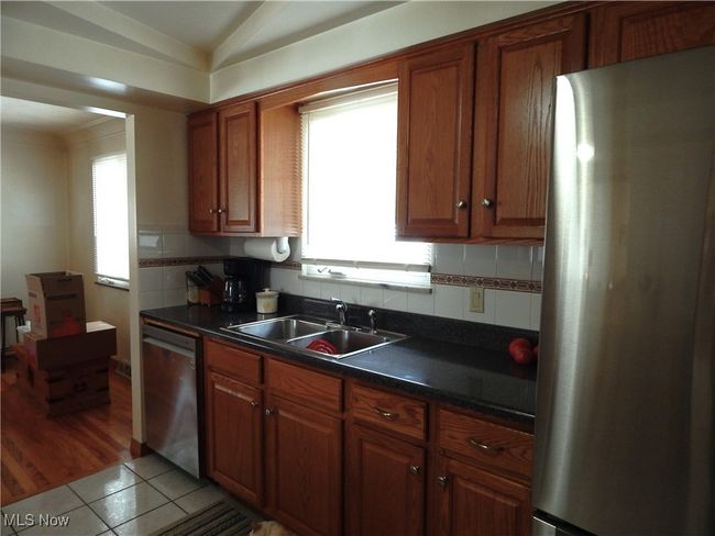 Kitchen featuring stainless steel appliances and sink, with tasteful backsplash. | Image 11