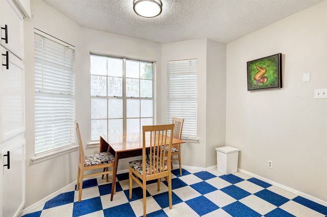 Dining room with light checkered flooring, a textured ceiling, healthy amount of natural light, and baseboards | Image 8