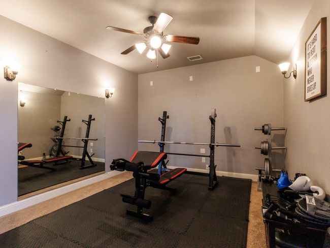 This flex space is currently being utilized as a home gym and includes a ceiling fan. | Image 21