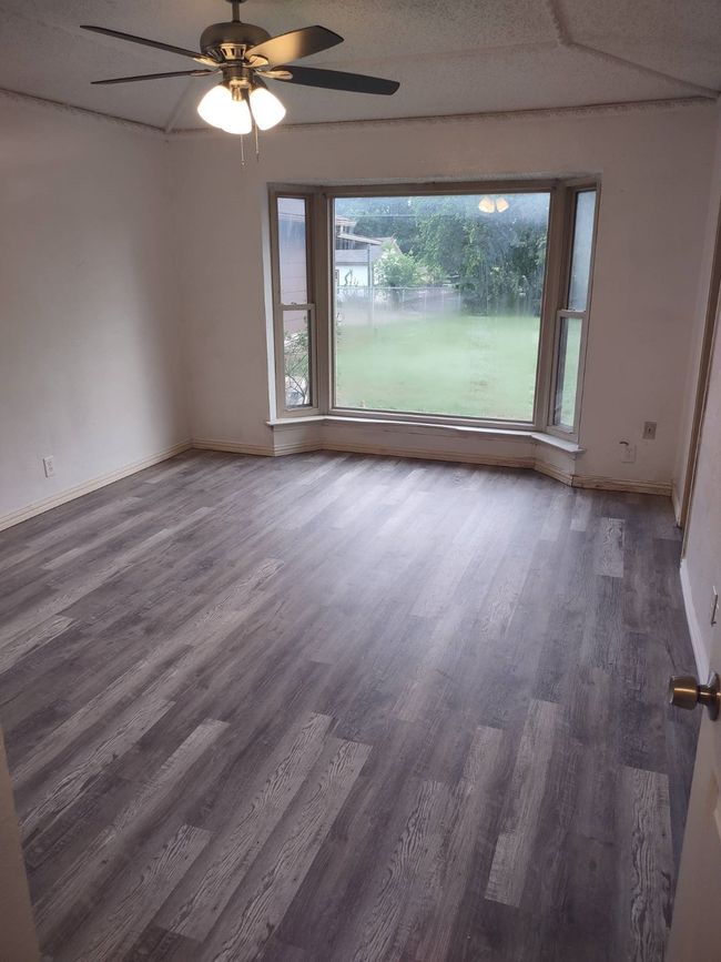 Empty room featuring wood finished floors, a ceiling fan, and baseboards | Image 4