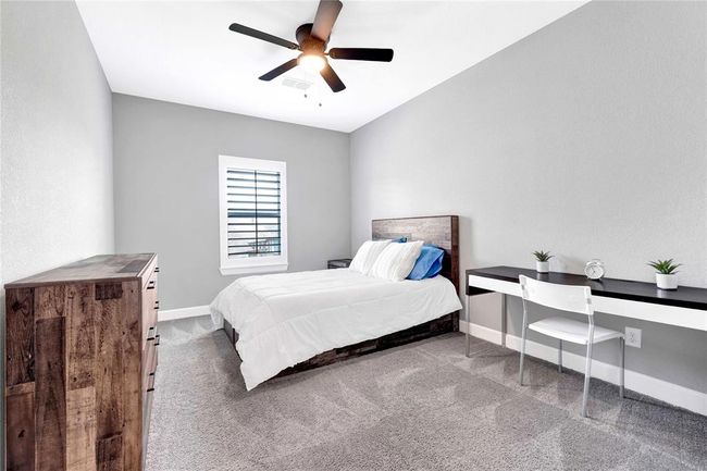 Oversized secondary bedroom with ceiling fan and plantation shutters | Image 38
