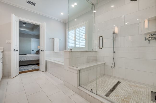 Bathroom with crown molding, connected bathroom, a stall shower, visible vents, and a bath | Image 17