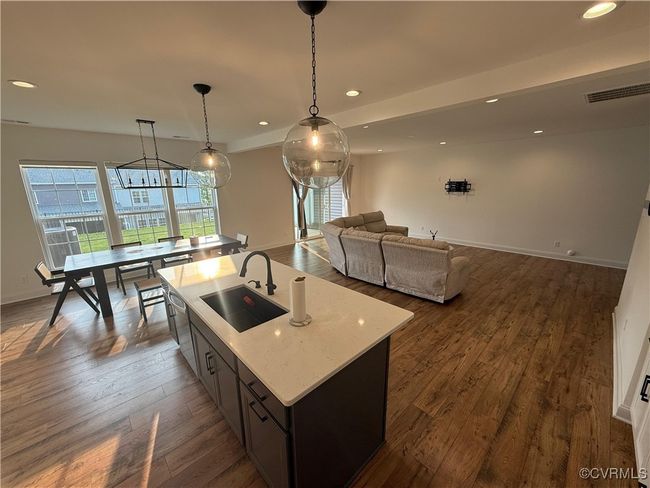 Kitchen featuring a sink, recessed lighting, an island with sink, dark wood finished floors, and baseboards | Image 22