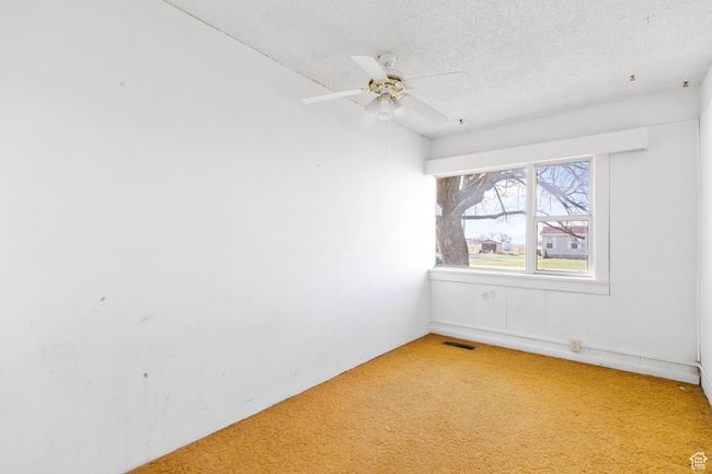 Spare room with a textured ceiling, visible vents, ceiling fan, and light colored carpet | Image 26