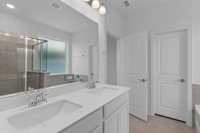 Bathroom featuring double vanity, tile patterned floors, tiled shower, a tub, and recessed lighting | Image 23