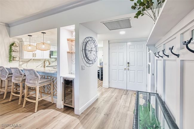 Foyer with light wood finished floors, beverage cooler, and recessed lighting | Image 11