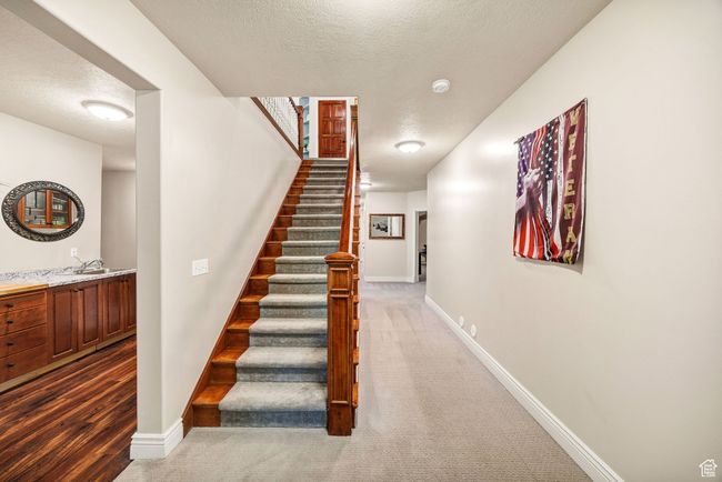 Stairs with a textured ceiling and carpet floors | Image 57